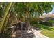 Palm-shaded backyard with a dining set, lounge seating, and brick patio at 745 Bruce Ave, Clearwater Beach, FL 33767