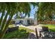 Lush backyard featuring a brick patio, grill, dining set, and tropical landscaping at 745 Bruce Ave, Clearwater Beach, FL 33767
