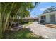 Green backyard featuring brick patio, dining set, grill, lounge area, and tropical plants at 745 Bruce Ave, Clearwater Beach, FL 33767