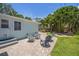 Serene backyard with brick patio, seating area, and lush tropical landscaping at 745 Bruce Ave, Clearwater Beach, FL 33767