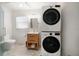 Bright bathroom features a modern vanity, toilet, and stacked washer/dryer at 745 Bruce Ave, Clearwater Beach, FL 33767