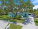 Charming light blue single-story home with a lush green lawn, mature tree, and inviting curb appeal at 745 Bruce Ave, Clearwater Beach, FL 33767