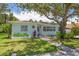 Charming single-story light blue home with a welcoming walkway, lush landscaping, and inviting curb appeal at 745 Bruce Ave, Clearwater Beach, FL 33767