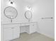Bright bathroom features double vanities, round mirrors, and modern fixtures at 7617 Alvina St, Tampa, FL 33625