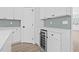 Kitchen area with white cabinets, wine cooler, and green tile backsplash at 7617 Alvina St, Tampa, FL 33625