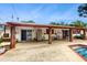 Backyard patio area featuring brick pillars, an in-ground swimming pool, and mature landscaping at 7710 Jackson Springs Rd, Tampa, FL 33615