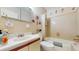 Bathroom featuring a sink, toilet, shower/tub combo with seahorse decals, and neutral-colored tile at 7710 Jackson Springs Rd, Tampa, FL 33615