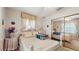 A bedroom featuring floral wallpaper, window treatments and bedding, a mirror closet, and neutral carpet at 7710 Jackson Springs Rd, Tampa, FL 33615