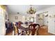 Charming dining room with chandelier, hardwood floors, and decorative wallpaper, adjacent to living areas at 7710 Jackson Springs Rd, Tampa, FL 33615