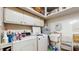 Functional laundry room equipped with a washer, dryer, utility sink, storage cabinets, and cleaning supplies at 7710 Jackson Springs Rd, Tampa, FL 33615
