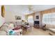 Traditional living room featuring neutral-toned sectional, plush carpeting, and abundant natural light at 7710 Jackson Springs Rd, Tampa, FL 33615