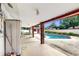 Covered patio view with brick pillars overlooking a private in-ground swimming pool and lush backyard at 7710 Jackson Springs Rd, Tampa, FL 33615