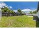 Large backyard featuring a green lawn, mature trees, privacy fencing, and patio area at 7815 Shadow Run Dr, Largo, FL 33773