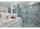 Modern bathroom with double sinks, sleek lighting, and glass-enclosed shower at 7815 Shadow Run Dr, Largo, FL 33773