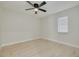 Bright bedroom featuring light wood floors, a ceiling fan, and a window for natural light at 7815 Shadow Run Dr, Largo, FL 33773