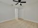Neutral bedroom with light wood floors and ceiling fan leads into closet and next room at 7815 Shadow Run Dr, Largo, FL 33773