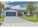 Charming single-story home featuring a well-maintained lawn, a blue painted driveway and a mailbox at 7815 Shadow Run Dr, Largo, FL 33773