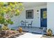 A cozy patio with a table and chairs next to a blue front door and decorative patterned tile at 7815 Shadow Run Dr, Largo, FL 33773