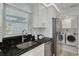 Well-equipped kitchen featuring black granite countertops and white cabinets at 7815 Shadow Run Dr, Largo, FL 33773