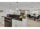 Open-concept kitchen with modern appliances, a breakfast bar, and seamless flow into the dining and living areas at 7815 Shadow Run Dr, Largo, FL 33773