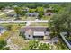 Aerial view of the home with a driveway, lawn and surrounded by other homes and large trees at 9259 Marler Rd, Spring Hill, FL 34608