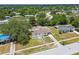 High up view of the property surrounded by mature trees and manicured lawns in a residential neighborhood at 9259 Marler Rd, Spring Hill, FL 34608