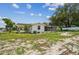 Spacious backyard with a well-maintained lawn and a cozy, screened-in porch, perfect for outdoor gatherings at 9259 Marler Rd, Spring Hill, FL 34608