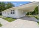 View of the home's exterior showing the white textured siding, carport, and driveway at 9259 Marler Rd, Spring Hill, FL 34608