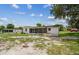 Rear exterior view of a well-maintained home featuring a screened-in porch and a spacious backyard at 9259 Marler Rd, Spring Hill, FL 34608