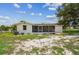 The back exterior of the home, showcasing a screened porch and freshly landscaped surroundings at 9259 Marler Rd, Spring Hill, FL 34608