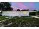 Charming single-story home featuring a fresh white exterior and cozy carport under a lovely pink and blue sky at 9259 Marler Rd, Spring Hill, FL 34608