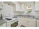 A bright kitchen showcasing white cabinets, grey granite countertops and white appliances at 9259 Marler Rd, Spring Hill, FL 34608