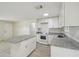 The kitchen is filled with white cabinets, grey granite countertops and an island at 9259 Marler Rd, Spring Hill, FL 34608