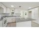 Lovely kitchen with white cabinets, stone countertops, island, and stainless steel appliances at 9259 Marler Rd, Spring Hill, FL 34608