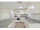 The kitchen features white cabinets, grey granite countertops, and stainless steel appliances at 9259 Marler Rd, Spring Hill, FL 34608