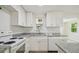 Bright kitchen featuring white cabinets, grey granite countertops and stainless steel appliances at 9259 Marler Rd, Spring Hill, FL 34608