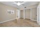 Bright bedroom featuring neutral walls, ceiling fan, tile flooring, and a spacious closet at 10033 64Th N Ave # 4, St Petersburg, FL 33708