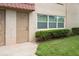 Exterior shot of the condo building showing a unit entrance, a window, and a patch of grass at 10033 64Th N Ave # 4, St Petersburg, FL 33708
