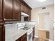 Kitchen area featuring white appliances, granite counters, and dark cabinets at 10033 64Th N Ave # 4, St Petersburg, FL 33708