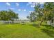 Expansive fenced back yard with well-manicured lawn and lush trees overlooking a tranquil lake at 1012 Seminole Sky Dr, Ruskin, FL 33570