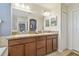 Bright bathroom with a double vanity, granite counters, a tiled floor, and a large mirror at 1012 Seminole Sky Dr, Ruskin, FL 33570