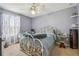 Comfortable bedroom with lavender walls, carpet floors, a ceiling fan, and a window with decorative curtains at 1012 Seminole Sky Dr, Ruskin, FL 33570