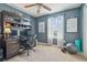 Home office with a built-in desk, dark walls, a ceiling fan, and a large window with natural light at 1012 Seminole Sky Dr, Ruskin, FL 33570
