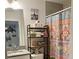 Cozy bathroom featuring an ornate shower curtain and over-the-toilet shelving unit at 10824 Quickwater Ct, Riverview, FL 33569