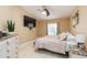 Bedroom featuring neutral color scheme, ceiling fan, tv, and comfortable bed at 11913 Butler Woods Cir, Riverview, FL 33579