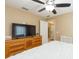 Bedroom with a large window, television, dresser, and ceiling fan at 11913 Butler Woods Cir, Riverview, FL 33579