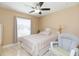 Cozy bedroom with a ceiling fan, neutral-toned walls, and large window for natural light at 11913 Butler Woods Cir, Riverview, FL 33579