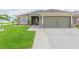 Lovely single-Gathering home featuring an attached two-car garage, a tidy lawn, and a welcoming entryway at 11913 Butler Woods Cir, Riverview, FL 33579