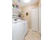 Well-organized laundry room with modern washer and dryer, shelving, and tile floors at 11913 Butler Woods Cir, Riverview, FL 33579