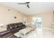 Comfortable living room featuring sliding glass doors, neutral walls, and ceiling fan at 11913 Butler Woods Cir, Riverview, FL 33579